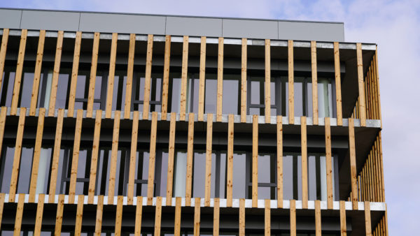 Facade of wooden modern building clad in ecological wood concept of sustainable construction. Image: Dreamstime
