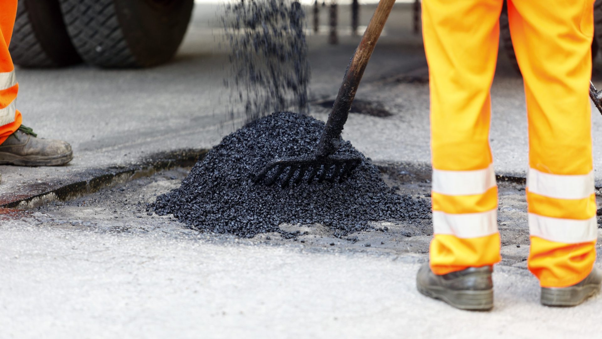 potholes report - Worker repairing a pothole