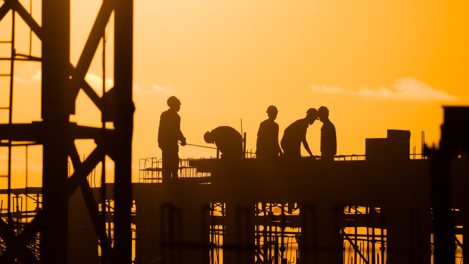 Construction site workers at sunset