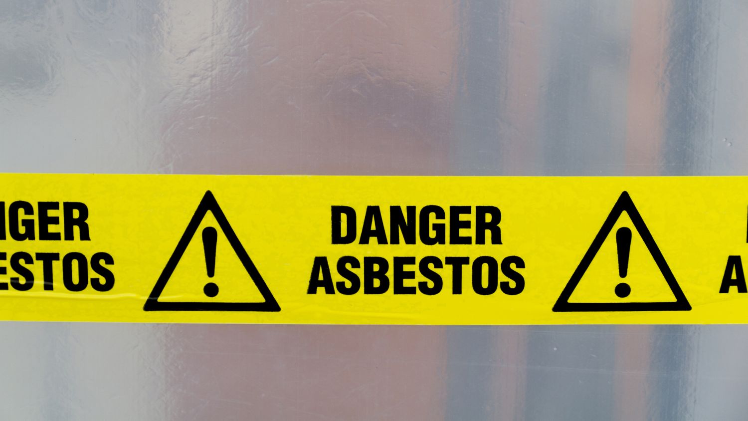 A yellow cordon reading 'Danger asbestos'