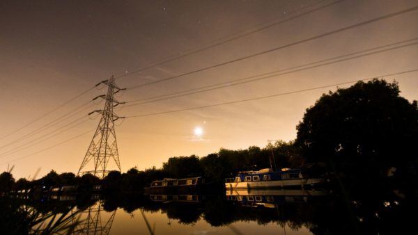 Evening scene of a London canal with moon, electrical power lines and boat (Image: Dreamstime)