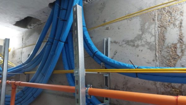 Pre-insulated pipework that has been installed in a building, running up into a hole in the ceiling