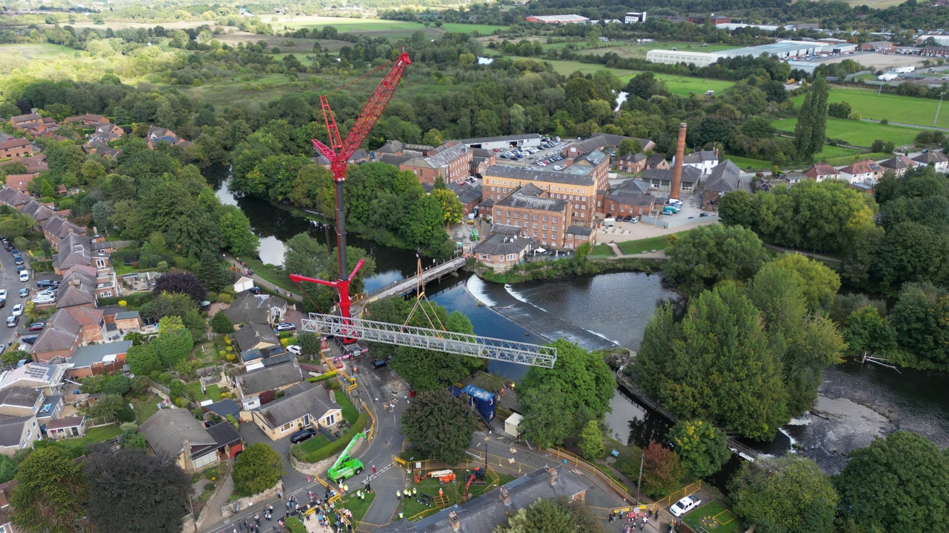 A crane lifts the temporary bridge in Darley Abbey