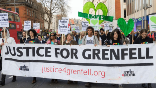 A very big group of people behind a banner that says 'Justice for Grenfell'