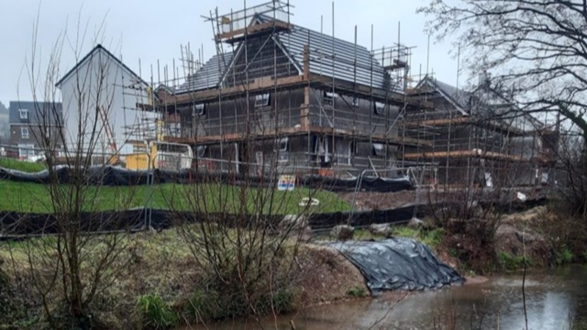 Taylor Wimpey - A construction site with a house and scaffolding. 