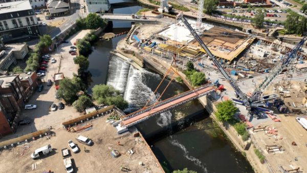 Aerial view of a bridge being lifted in place.