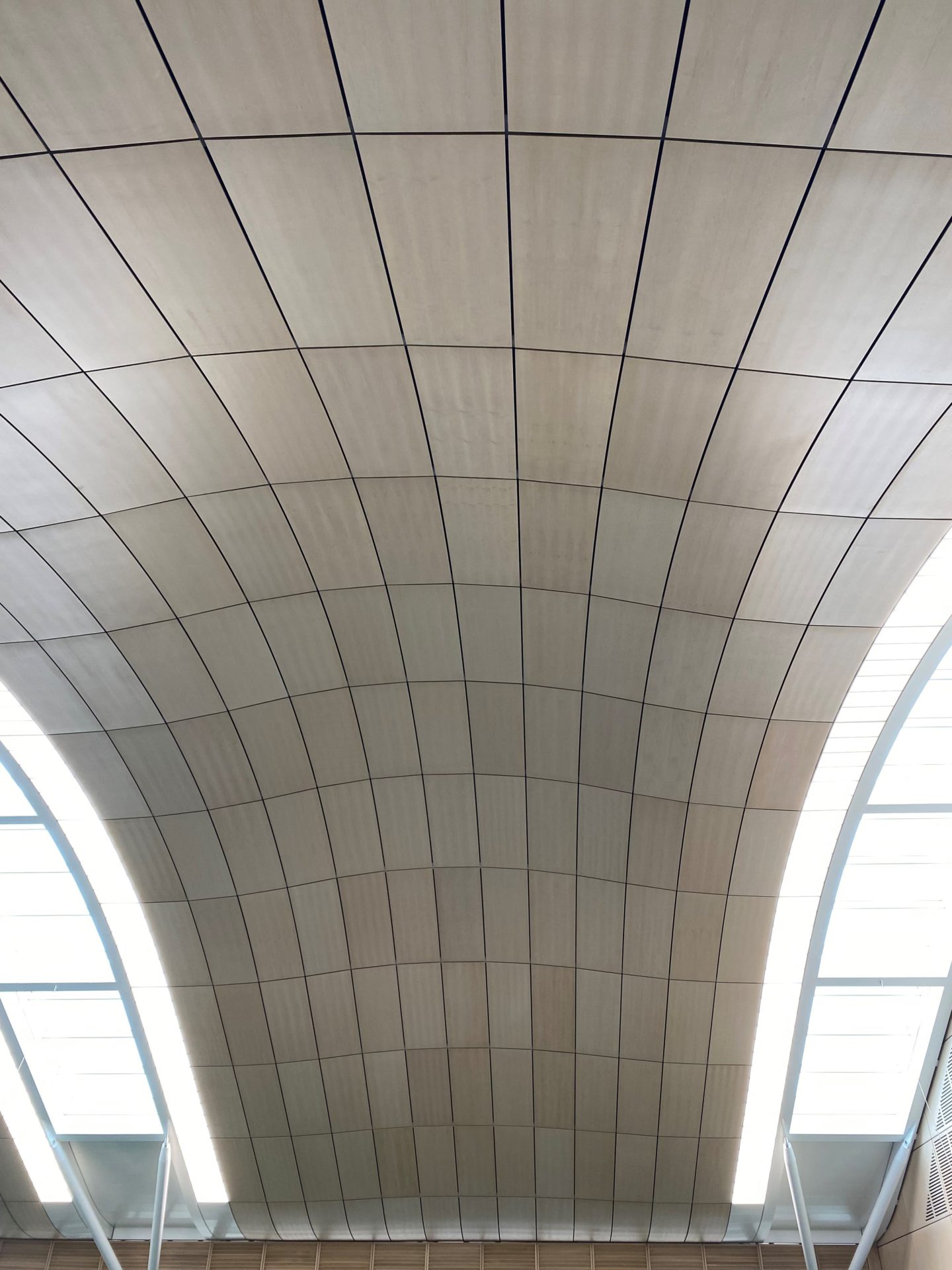 A curved ceiling with cladding.