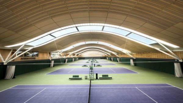 A view of an indoors tennis spots centre with tennis courts.