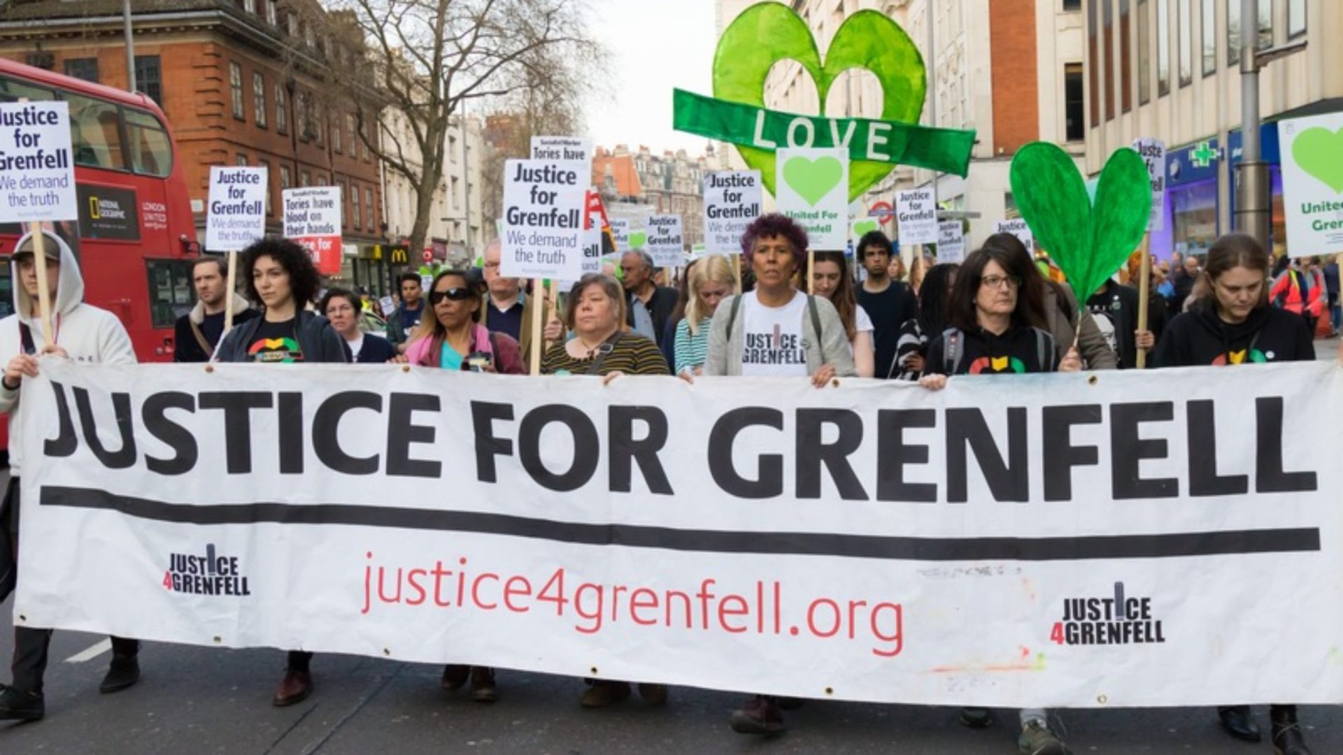 Grenfell Inquiry recommendations A group of people marching behind a banner that says 'Justice for Grenfell'