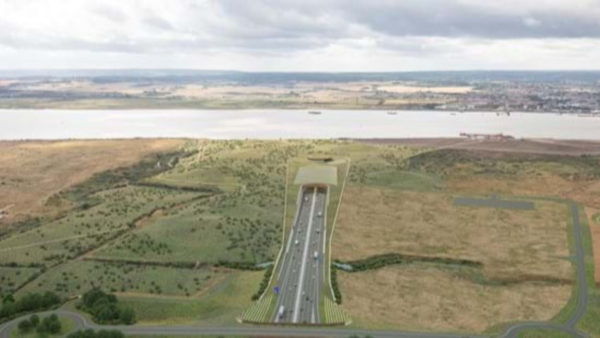 Aerial view of a motorway and a field and a river.