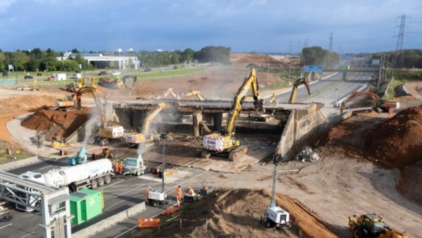 Heavy machinery in a construction site demolishing a bridge