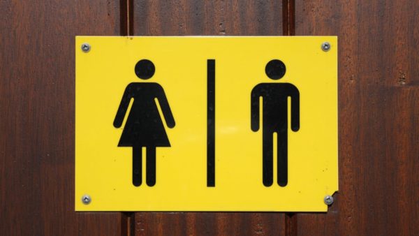 A female and male toilet sign on yellow background.