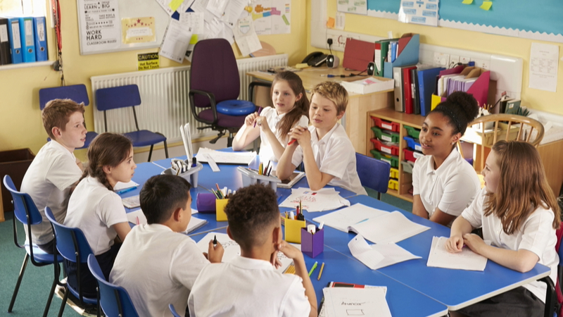 List of schools with RAAC - A classroom with school children sitting around a blue table.