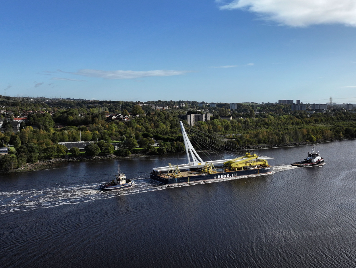 View of a large boat on a river carrying a bridge span.