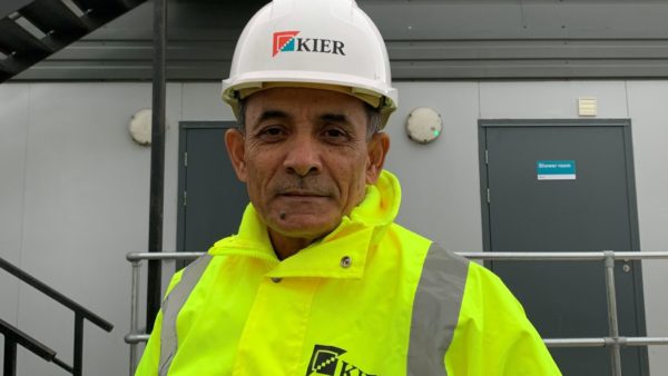 A man with a high-vis jacket and hard helmet looking at the camera.