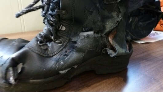 A black boot that has been destroyed.