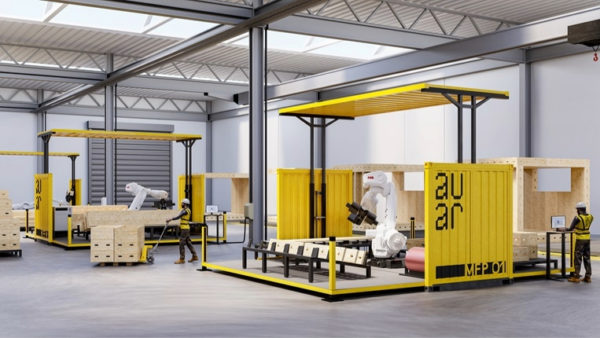 Inside of a factory, there's a yellow container and a robot assembling pieces.