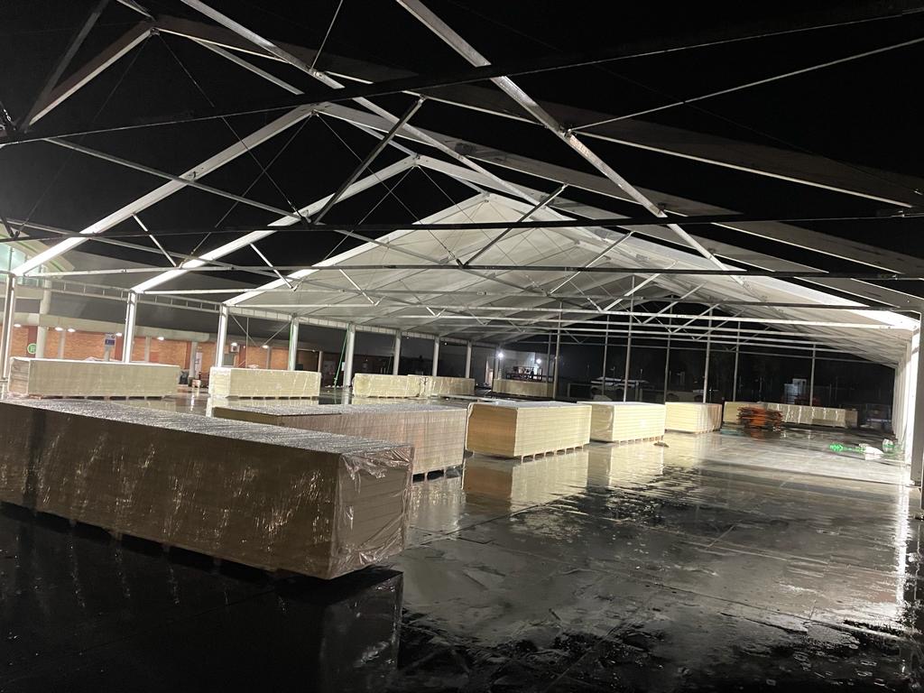 Inside of a big temporary structure with packed building materials.
