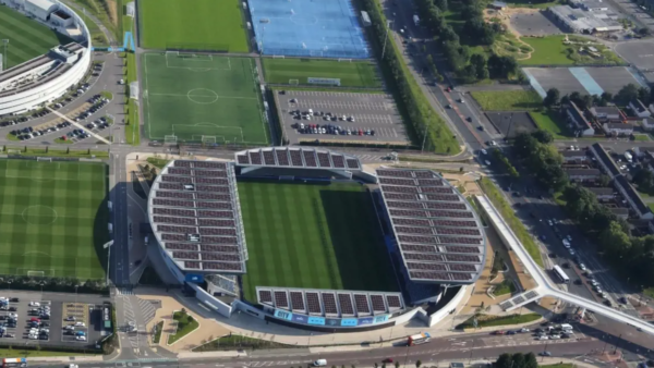A computer generated image of a stadium with solar panels on its roof