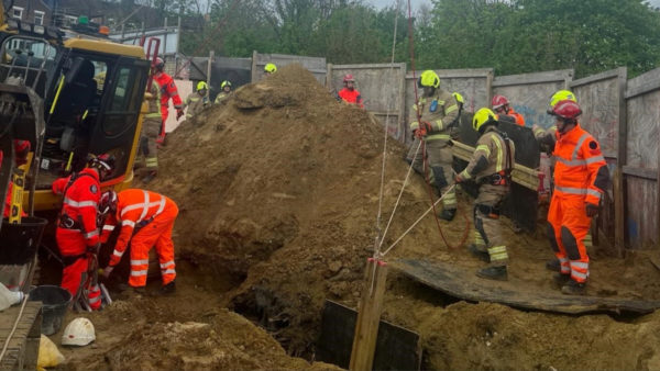 London firefighters and rescue services working on a trench to rescue a trapped man.