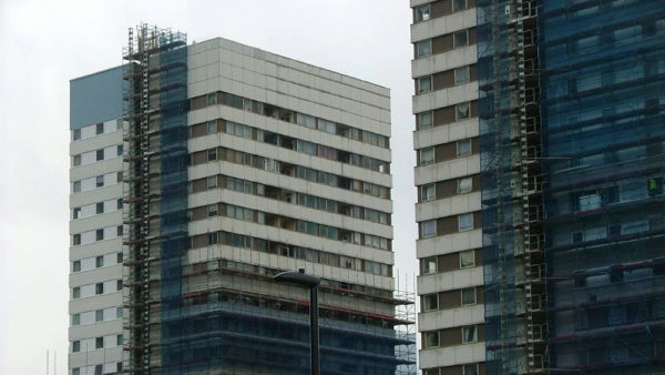 Two high-rises with scaffolding - cladding remediation remains slow in England
