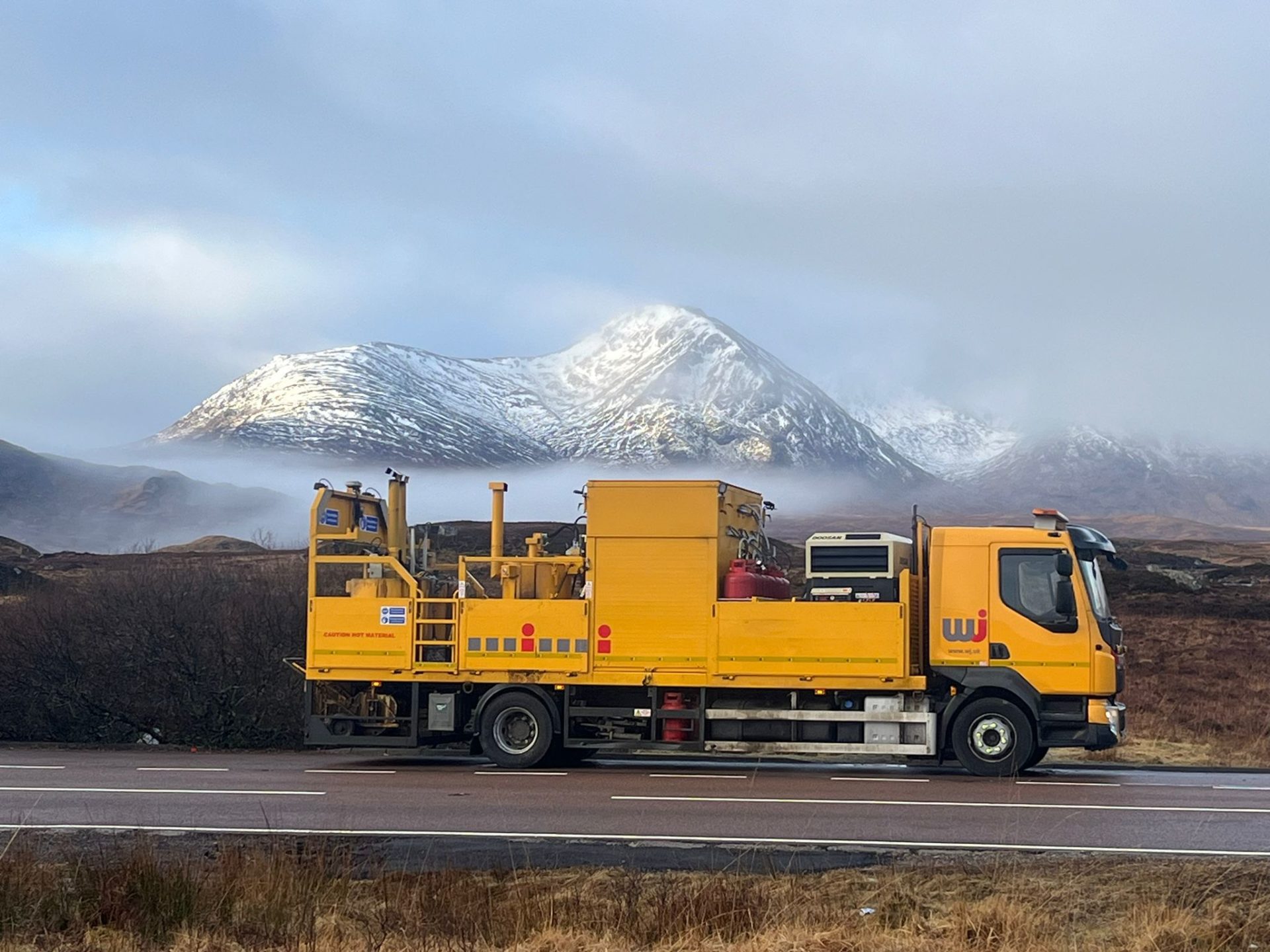 A big maintenance road truck on a road. There's a big mountain with snow in the background. WJ Group is showcasing photos taken by its workers to encourage more people into the sector.