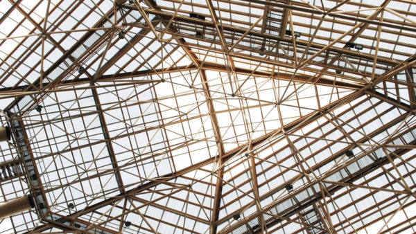 A steel frame viewed from below with the sun in the background.