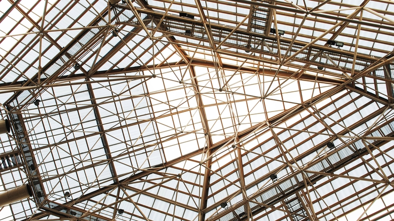 Structural Steel Design Awards - A steel frame viewed from below with the sun in the background.