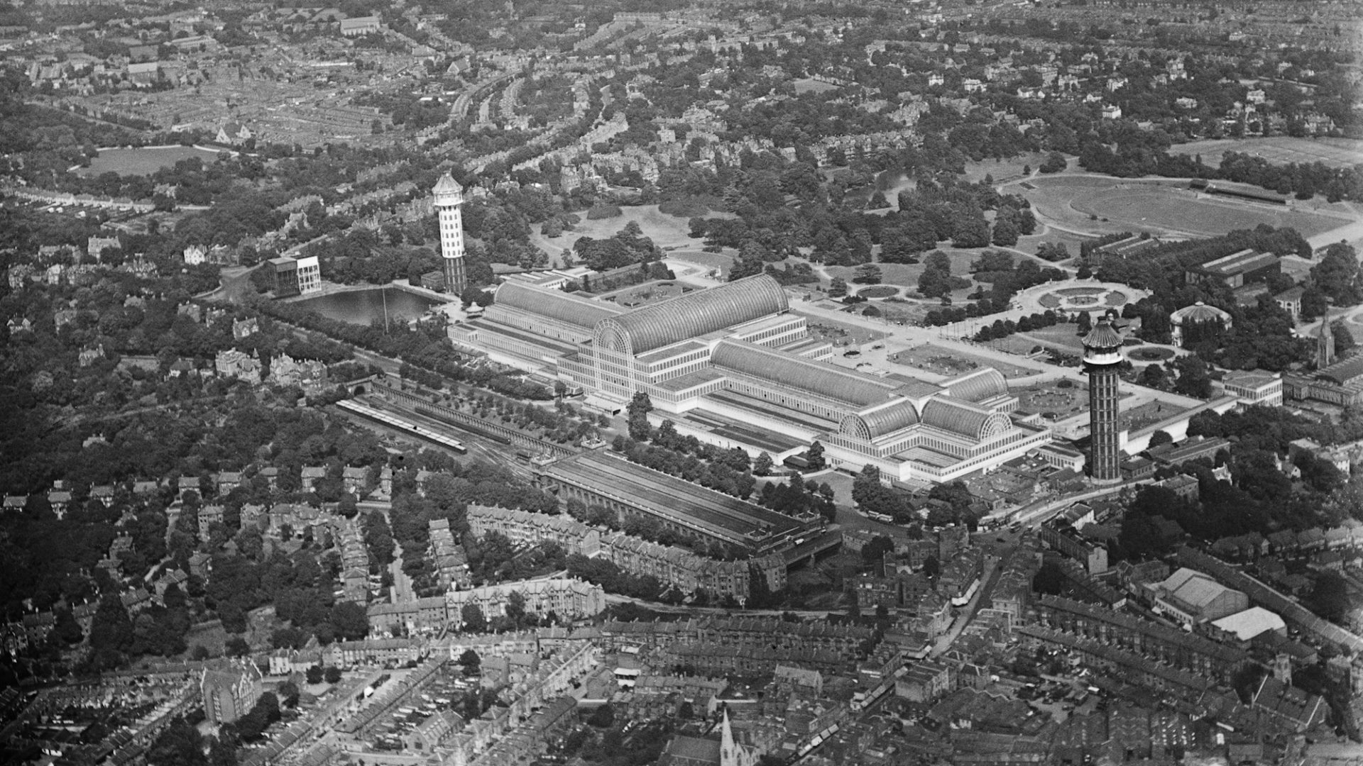 The original Crystal Palace in the 1930s, prior to the fire, with the old High Level station in the foreground (image: Historic England).