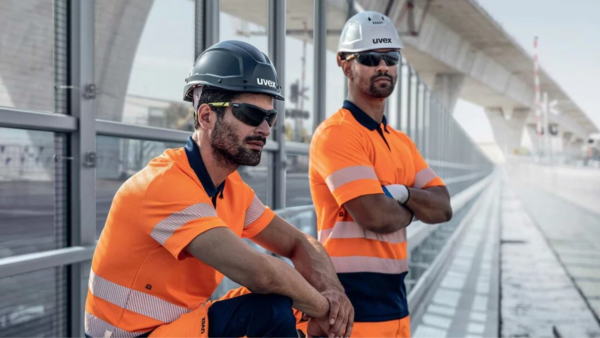 Two construction workers wearing PPE, including eye safety wear.