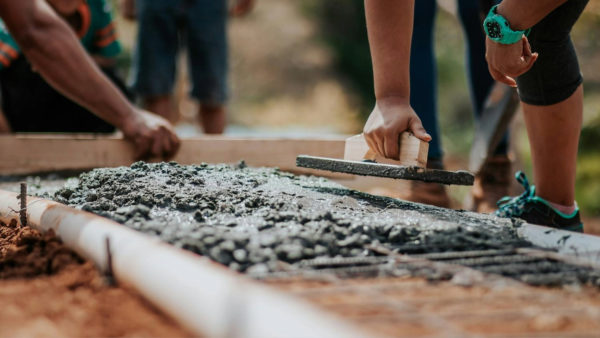 A worker's hand applying cement to a structure. Seven projects have been awarded public funding to advance concrete decarbonisation.