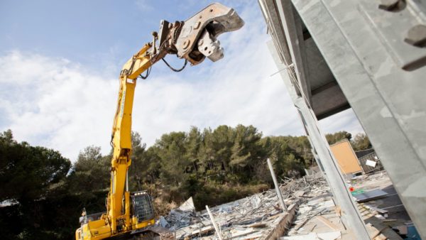 A yellow excavator carrying out demolition works on site - a civil nuclear site in Berkshire is the first to have been successfully decommissioned.