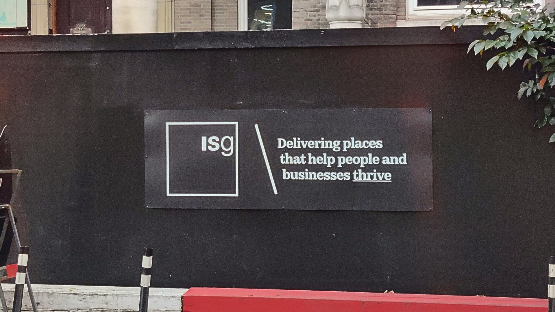 A black hoarding outside a closed ISG project. On it, there's a sign that says 