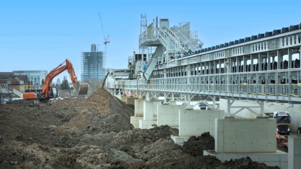 A big construction site with an excavator moving earth. Skanska Costain Strabag joint venture has secured funding to trial repurposed London Clay as a low carbon alternative to cement.