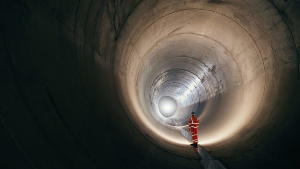 A worker in high-vis inside one of the huge tunnels that make the London super sewer