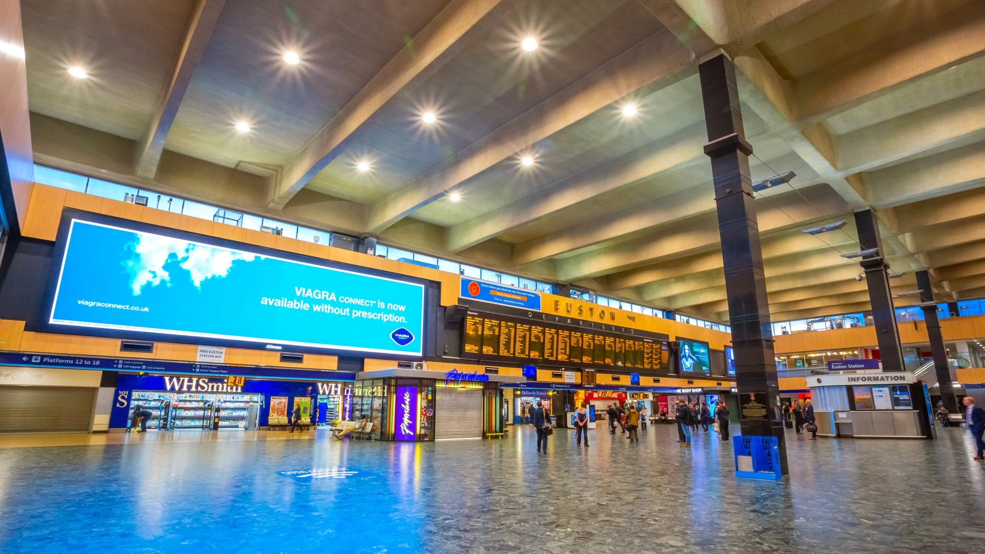 Concourse of London Euston station with a few passengers in the background and big screens showing train times and adverts. The rail minister has said the station is no longer in fit condition.   