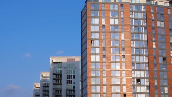 A row of tall modern apartment and office blocks in evening sunlight - The Institution of Structural Engineers has published technical guidance about preparing the structural aspects of Gateways 2 and 3 submissions for higher risk buildings.