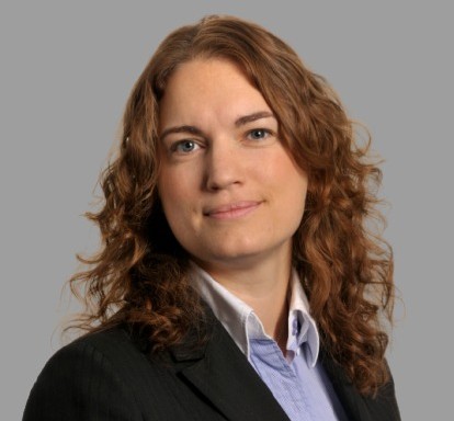 Mugshot of a woman with a jacket and blue and white shirt smiling at the camera. Her name is Charlotte Bloomfield and she is an employment law expert at Womble Bond Dickinson.