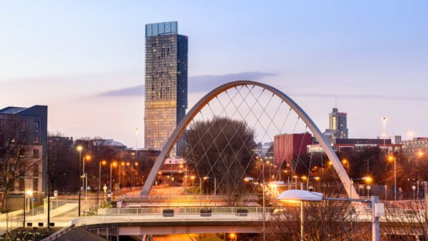 An arched bridge and a tower in the background part of the Manchester city skyline. Balfour Beatty is backing a new report by the Institute of Government setting recommendations to support metro mayors.