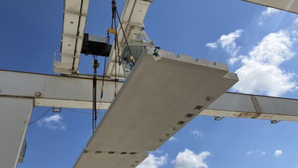 A precast plank being moved in place at a construction site - Skanska is using precast planks made of 50% slag cement at its 105 Victoria Street project