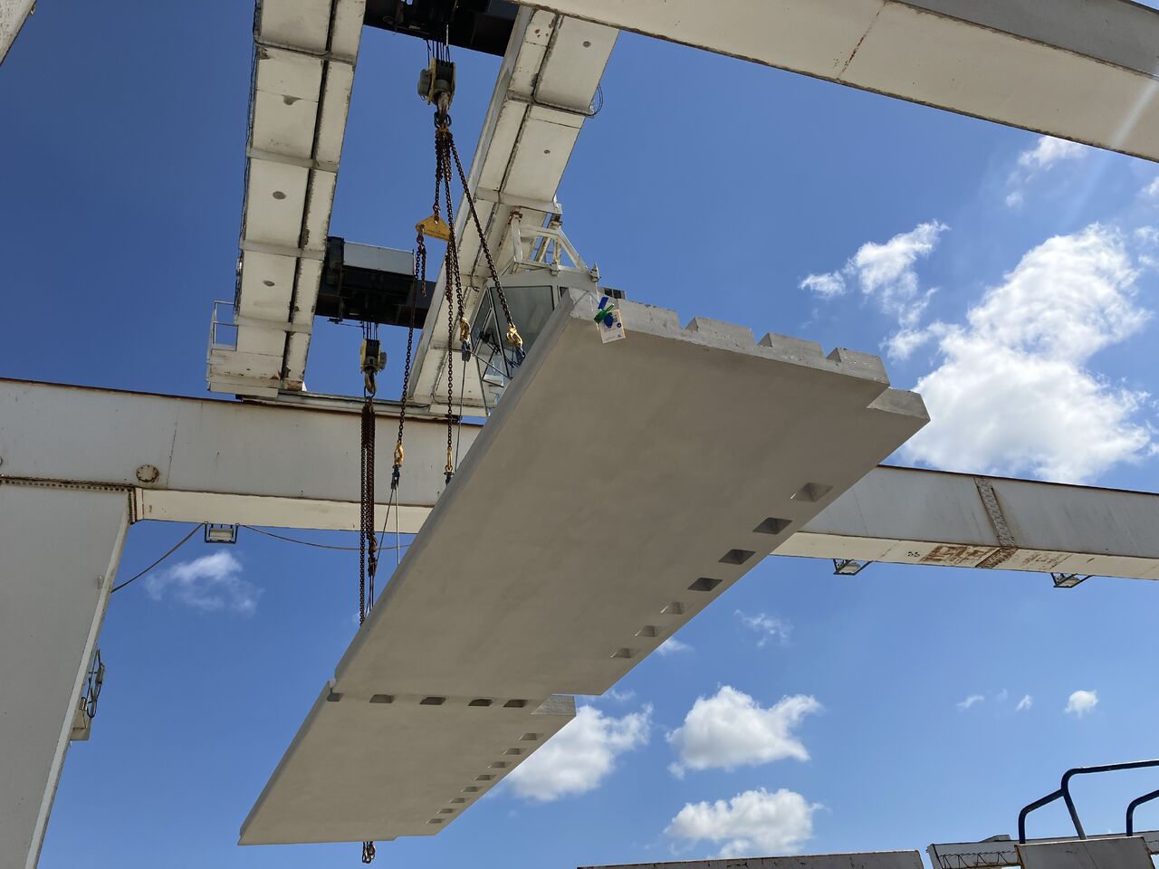 GGBS Skanska - A precast plank being moved in place at a construction site - Skanska is using precast planks made of 50% slag cement at its 105 Victoria Street project