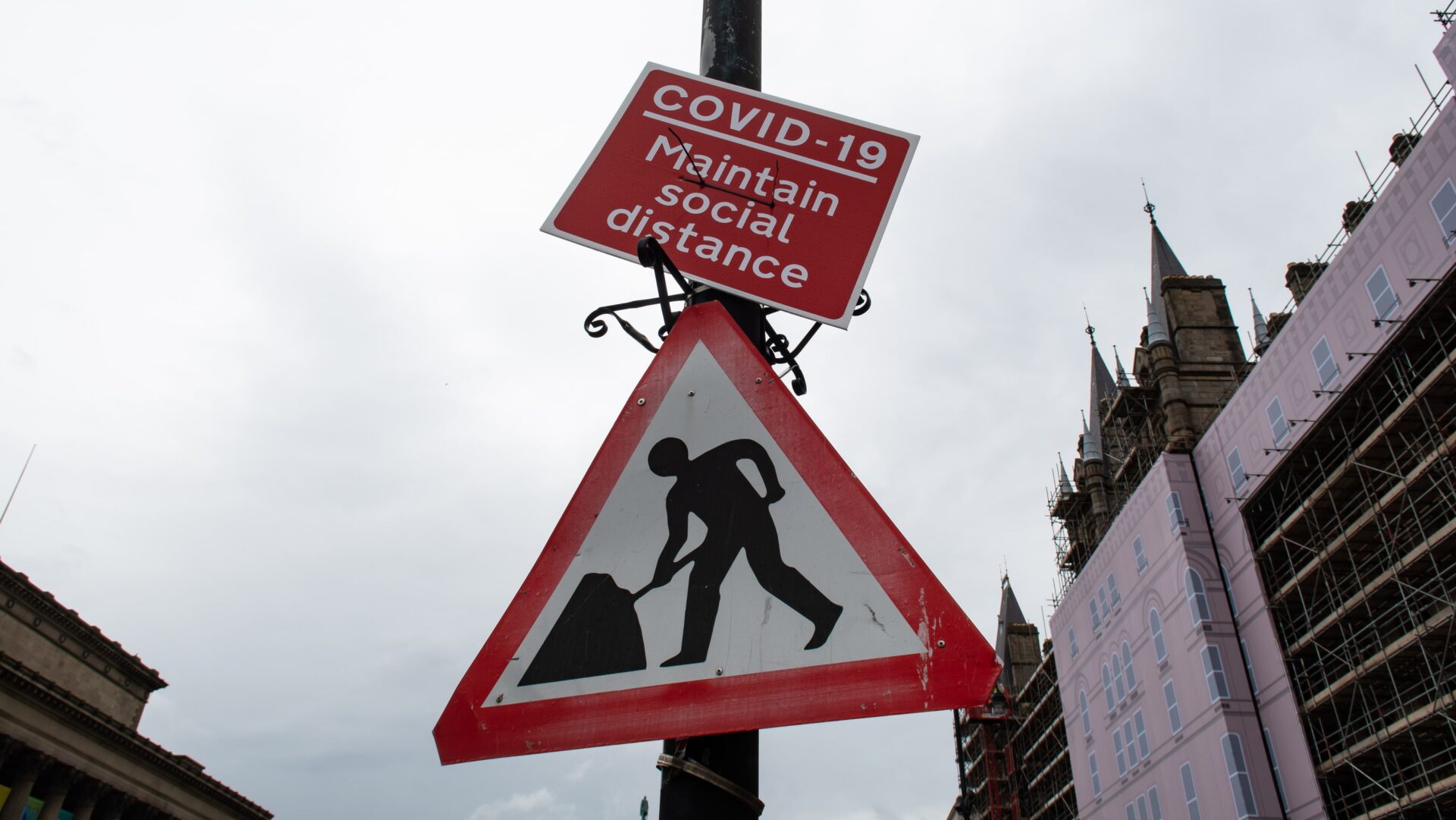 covid hybrid generation - Two street signs. Top sign reads Covid 19 Maintain social distance and lower sign is a construction site caution sign. BSI is calling for evidence on experiences of Covid career starters in the built environment