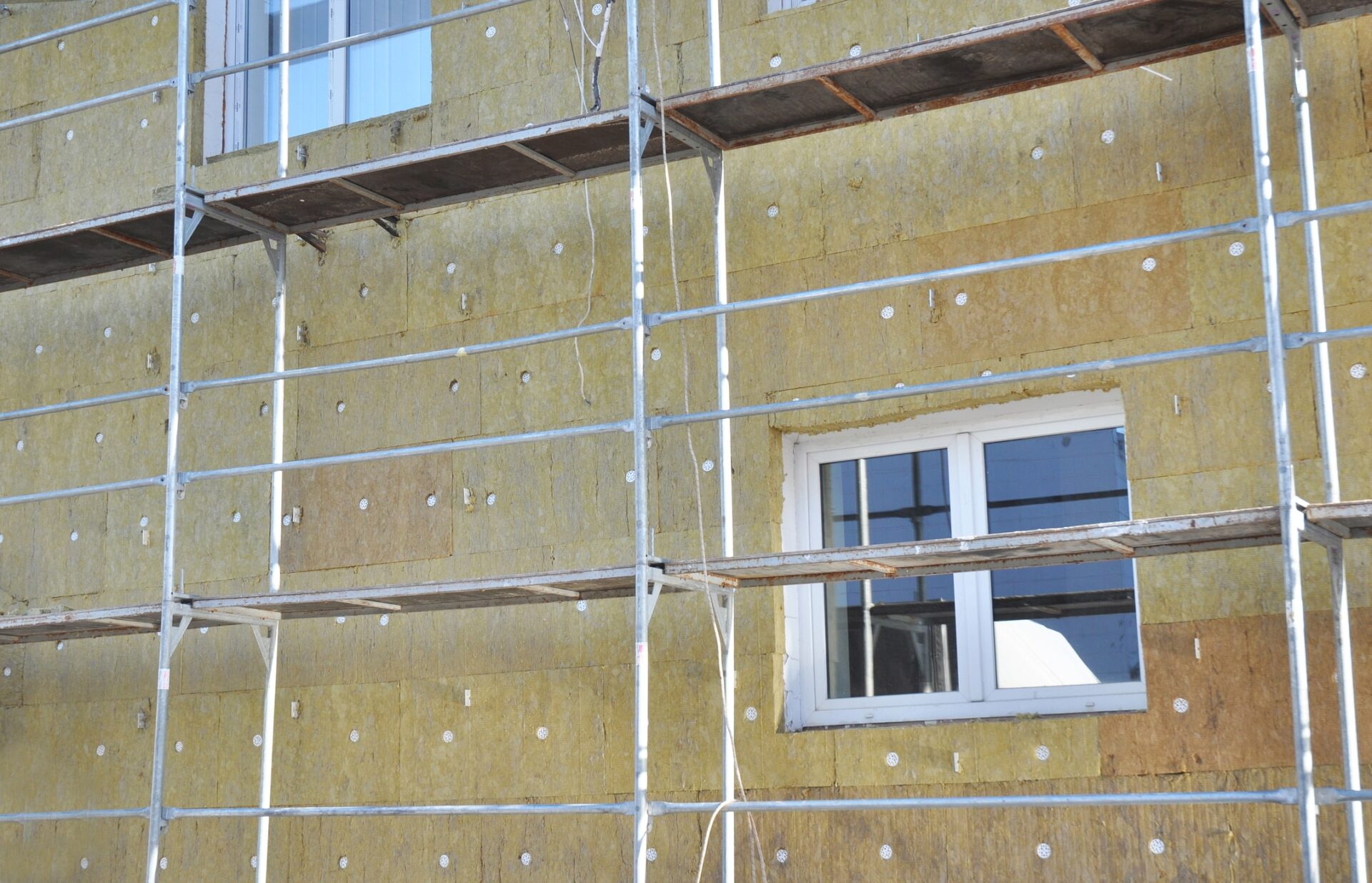 solid wall insulation - House facade renovation with mineral wool insulation boards outdoors -  the government has suspended 39 businesses who installed poor-quality insulation.