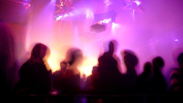 Dance floor inside a night club with blurred crowd in motion - this article discussed how mass fatality nightclub fires can be prevented.