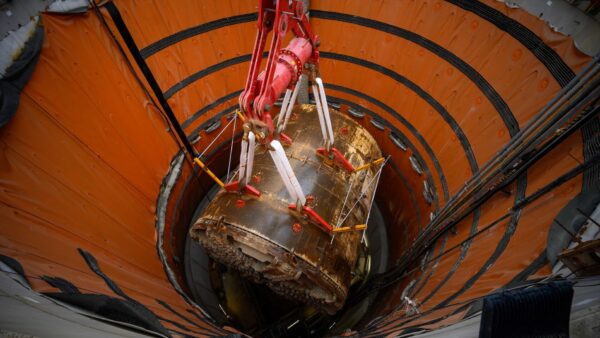 A giant boring tunnel machine being lifted from a shaft