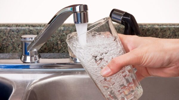 Close up of a person's hand filling glass from water tap - the government has launched a consultation on water-saving proposals
