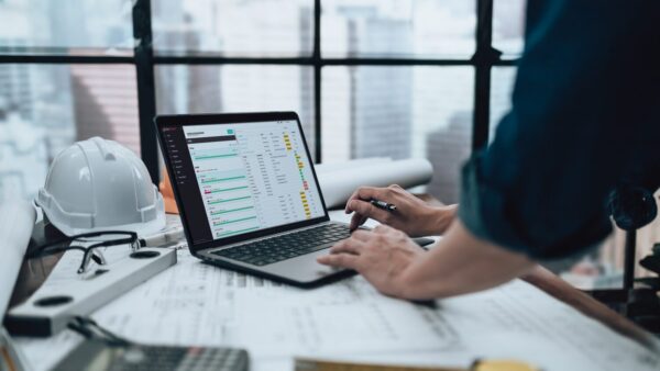 Image of a construction professional using a laptop for handover information