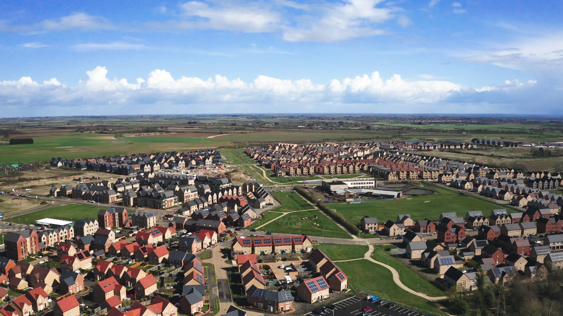 Homes England Northstowe Aerial view of a new town surrounded by green fields