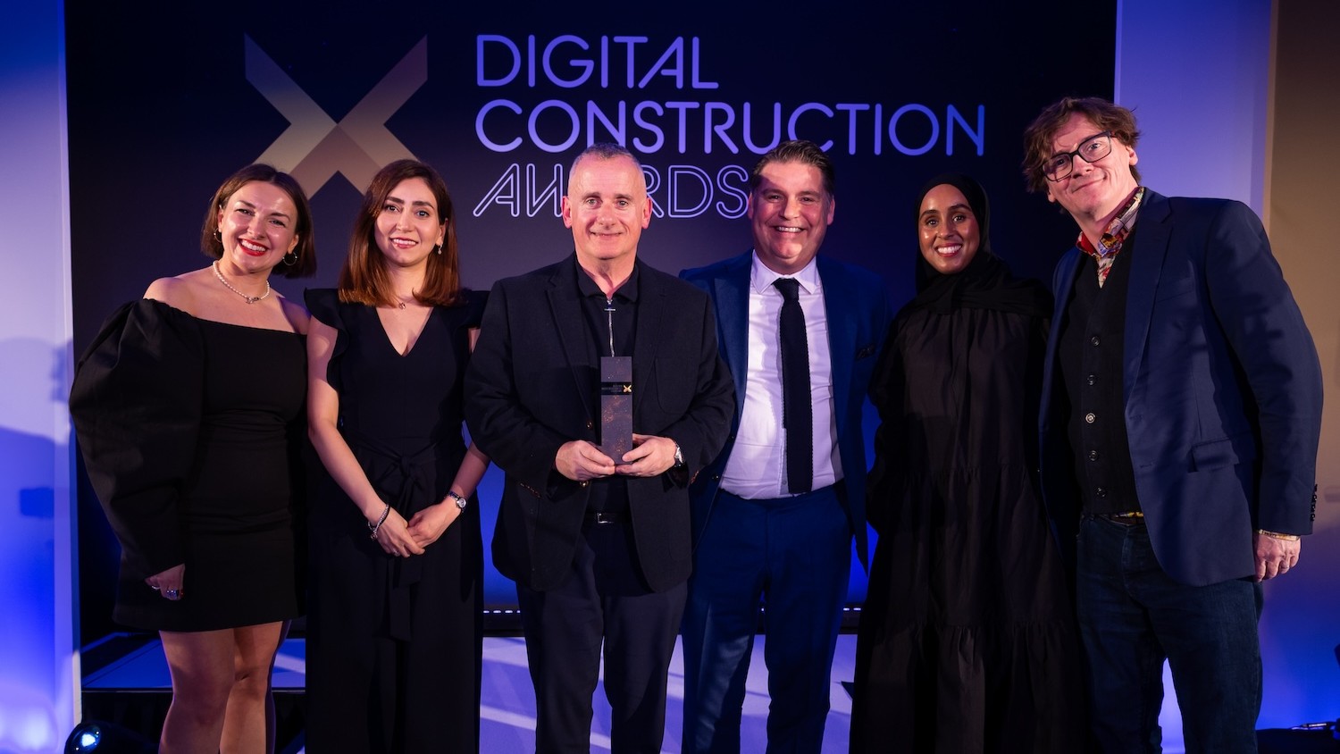 The Arup and IESVE team collect trophy from Ed Byrne (far right), Sagal Rooble of Chetwoods (second right) and Karolina Orecchini of Digital Construction Week (far left). Image: © 2026 – ASV Photography Ltd. www.ASVphotos.com
