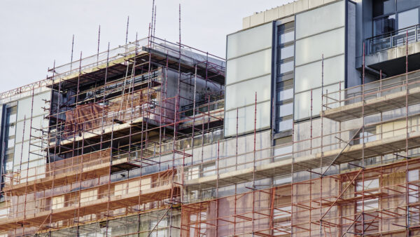 The latest building control gateway 2 update from the Building Safety Regulator (BSR) shows a continuing de-gumming of this new and complex process. The 12 weeks to 30 May saw an increase in approval rates across all categories of applications, including existing building safety projects, after it introduced an external remediation improvement plan in April. The plan introduced a new external remediation multidisciplinary team to mirror the Innovation Unit (IU) set up last September. This streamlines communication and processing through dedicated account managers. It also saw a recruitment drive to cut individual caseloads from an average of 25 down to around 10. For new builds, IU decisions overtook the number of new cases received in the period. Across all categories, BSR made 358 gateway 2 decisions, with a 75% approval rate. 65% of all decisions related to London cases. Applications representing 14,928 units were determined, of which 9,499 (64%) were approvals. There are currently 38,775 residential units in live cases. New applications for 13,964 units came in during the period. External remediation approvals up The IU approved 90% of cases – 28 out of 31 – in the period. London saw a 100% approval rate for its 19 case decisions. The regulator said this reflects the extra engagement with applicants. All-time IU approvals now stand at 43, with a median approval time of 22 weeks. The IU is currently managing 131 applications, representing 30,369 units. On external remediation, approval rates rose to 79% over the last 12 weeks, well above the minimum 65% end of year target for 2026. BSR credits operational improvements and intensive work to improve quality of applications. Currently, 16 legacy remediation applications from 2024 remain. A further 10 are on track to be determined in June. This is down from 42 outstanding at the beginning of 2026. BSR said the data show that 2026 applications are progressing faster than before. The average approval time is still 39 weeks in a rolling 12-week period, but BSR said this was “being skewed by our focus on closing out the older 2024/2025 applications”. People still waiting “We continue to see positive improvements in numbers of approvals for both new build and existing building remediation cases, as well as significantly faster decision times,” said acting BSR chief executive Charlie Pugsley. “This includes continued positive results from our Innovation Unit by working closely with applicants to safely resolve complex technical challenges. This positive engagement has seen a growing number of decisions and rising approval rates.” He added: “However, we recognise that people living in other unremediated buildings still want them to be fixed safely, and at pace.”